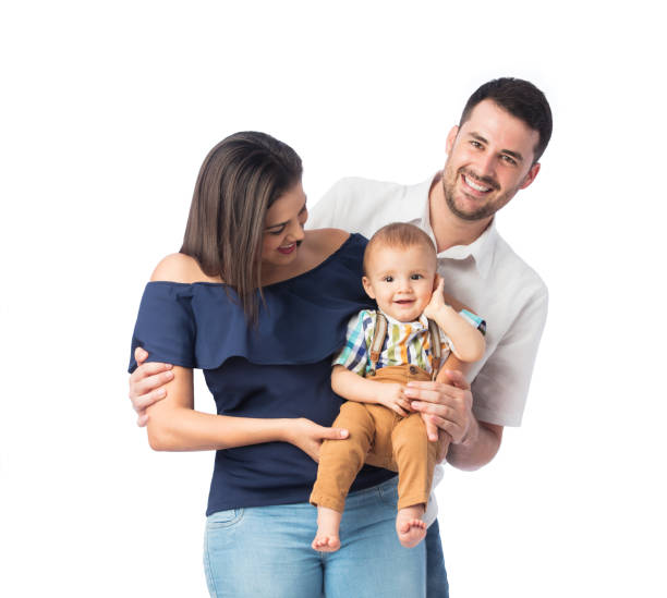 A playful latin family standing with a cute baby boy and smiling at the camera.